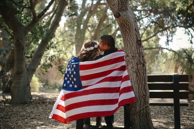 男人白天用美国国旗裹着女人的额头亲吻